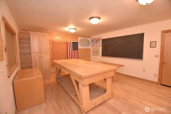 a kitchen with stainless steel appliances a stove a microwave a sink and white cabinets with wooden floor