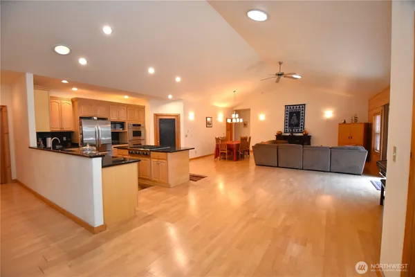 a living room with furniture kitchen view and a chandelier