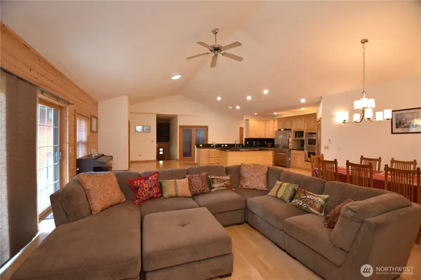 a living room with furniture a large window and kitchen view