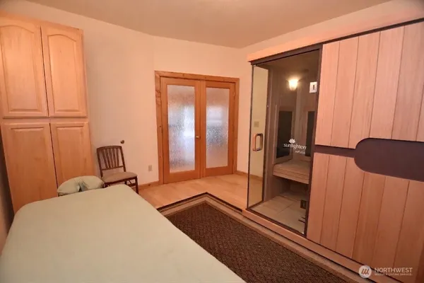 a large bed sitting in a room next to a lamp with a chandelier