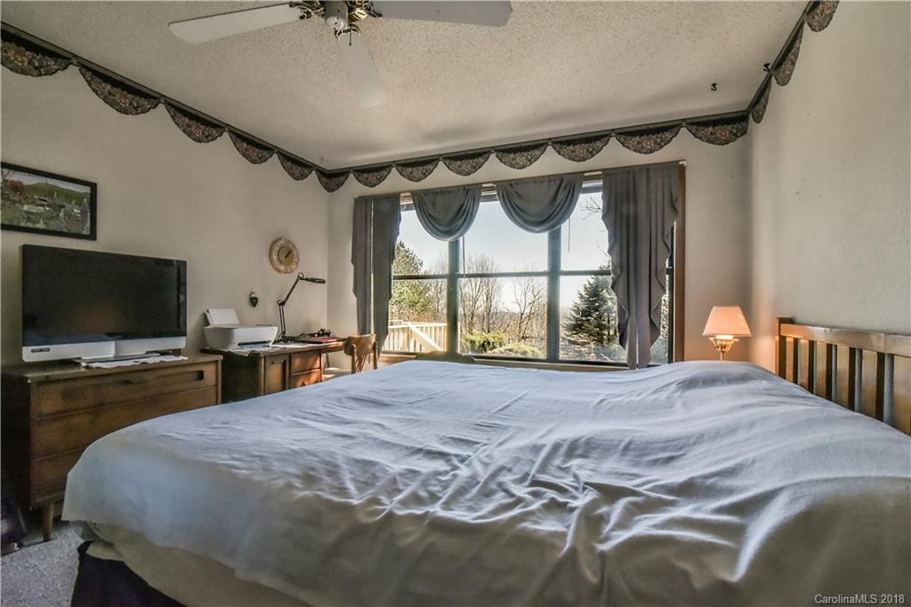 286 Pioneer Ridge Road Canton, NC 28716 - Photo 25 of 33 a bedroom with a bed and a flat screen tv