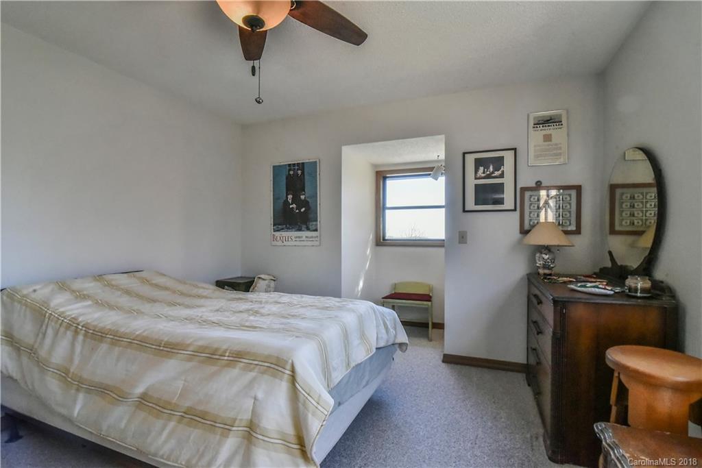 286 Pioneer Ridge Road Canton, NC 28716 - Photo 29 of 33 a bedroom with a bed a dresser and window