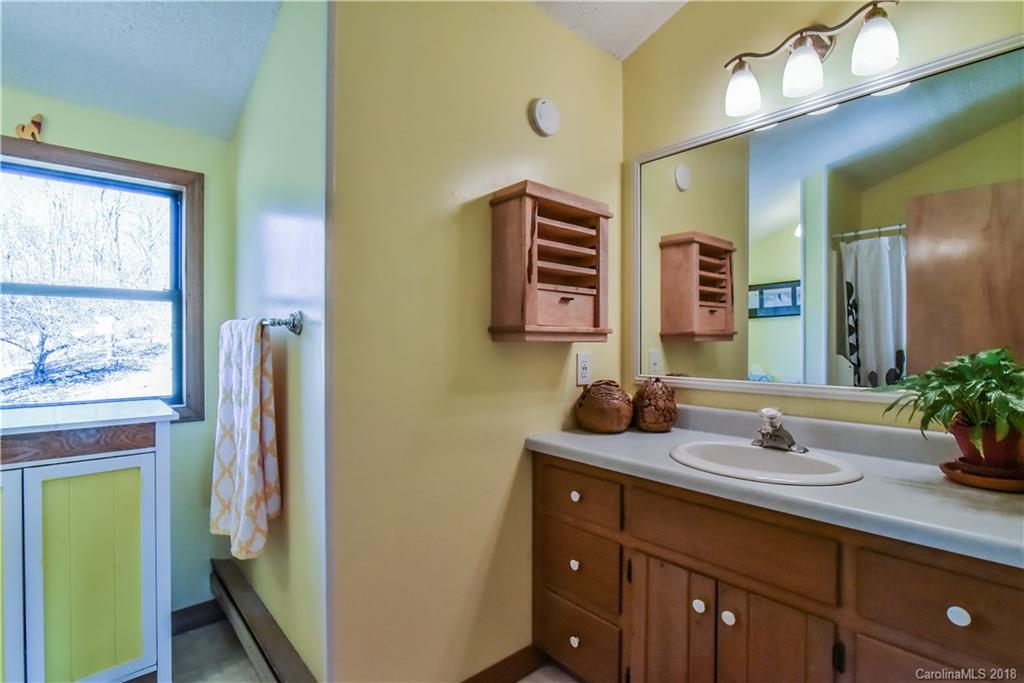 286 Pioneer Ridge Road Canton, NC 28716 - Photo 31 of 33 a bathroom with a sink and a mirror