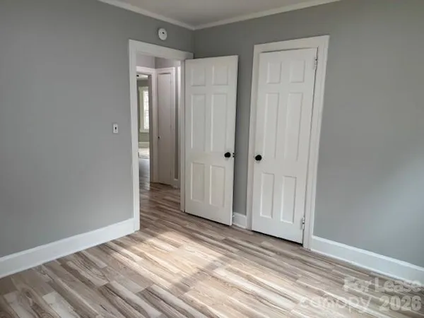 a view of a room with wooden floor and closet area