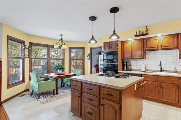 a kitchen that has a cabinets sink and chairs in it