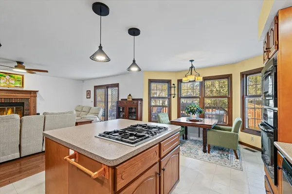 a kitchen with a stove a sink a dining table and chairs with wooden floor