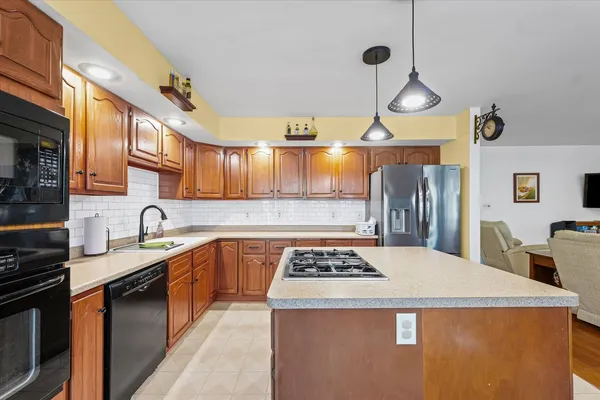a kitchen with stainless steel appliances granite countertop a sink a stove and a refrigerator