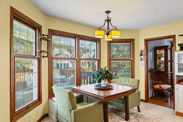 a dining room with furniture a chandelier and wooden floor