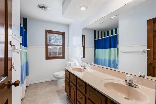 a bathroom with a double vanity sink mirror and toilet