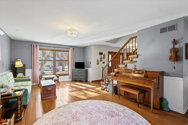 a living room with furniture a piano and a bookshelf