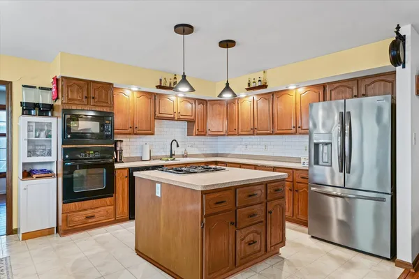 a kitchen with stainless steel appliances granite countertop a stove a refrigerator and a sink