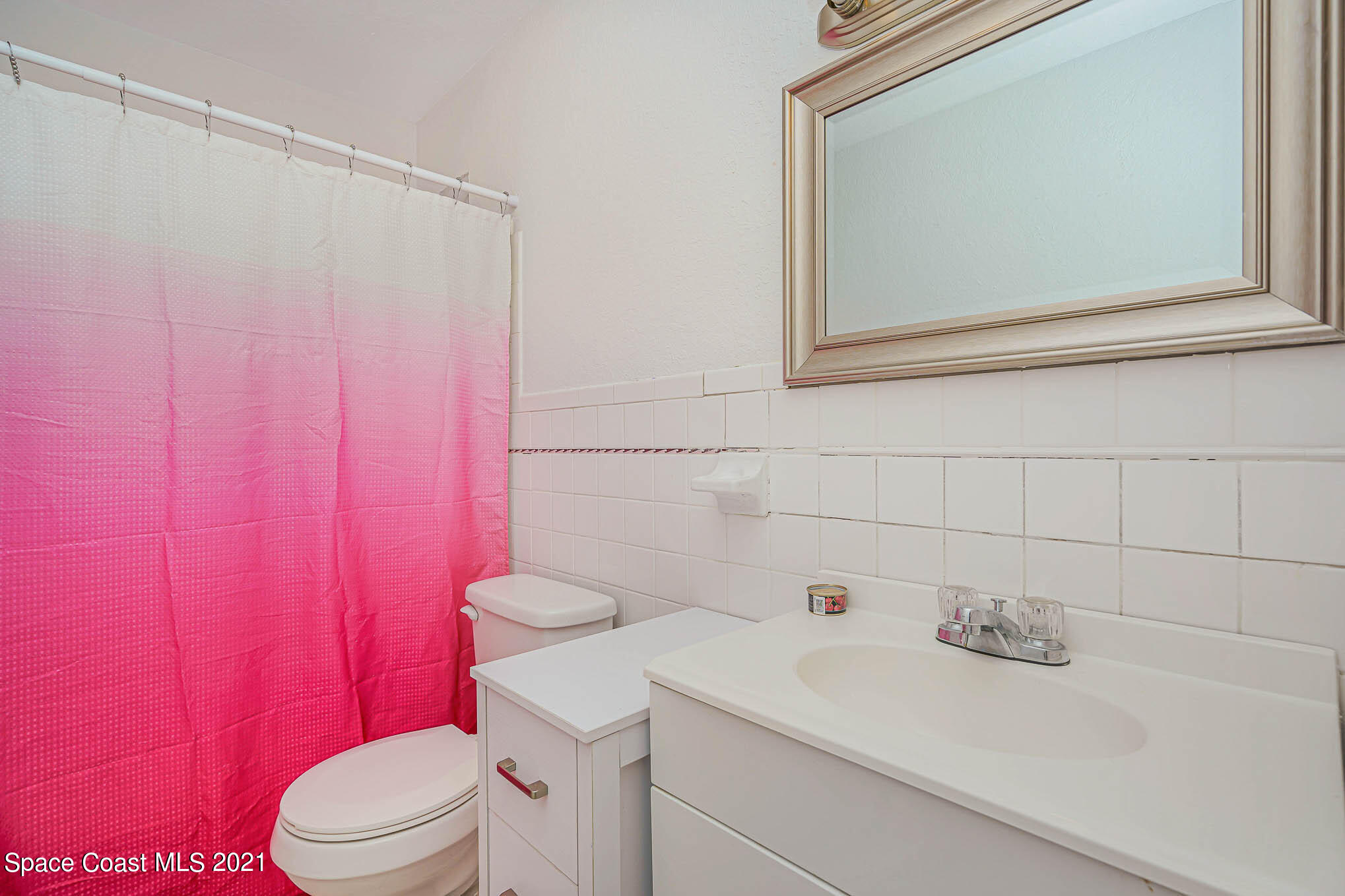 1120 North Carpenter Road Titusville, FL 32796 - Photo 19 of 22 a bathroom with a sink a toilet and shower curtain