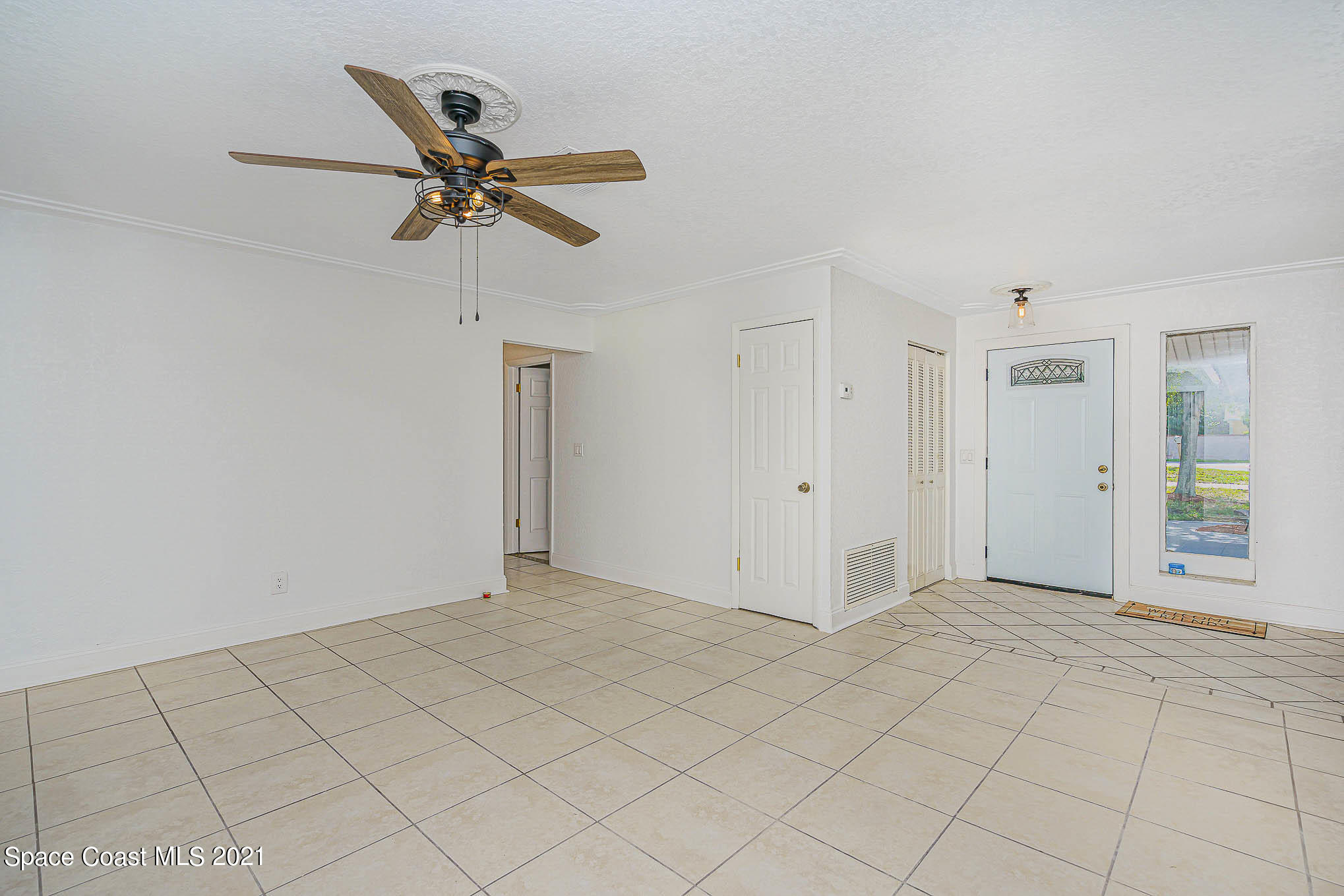 1120 North Carpenter Road Titusville, FL 32796 - Photo 4 of 22 a view of a livingroom with a ceiling fan and window