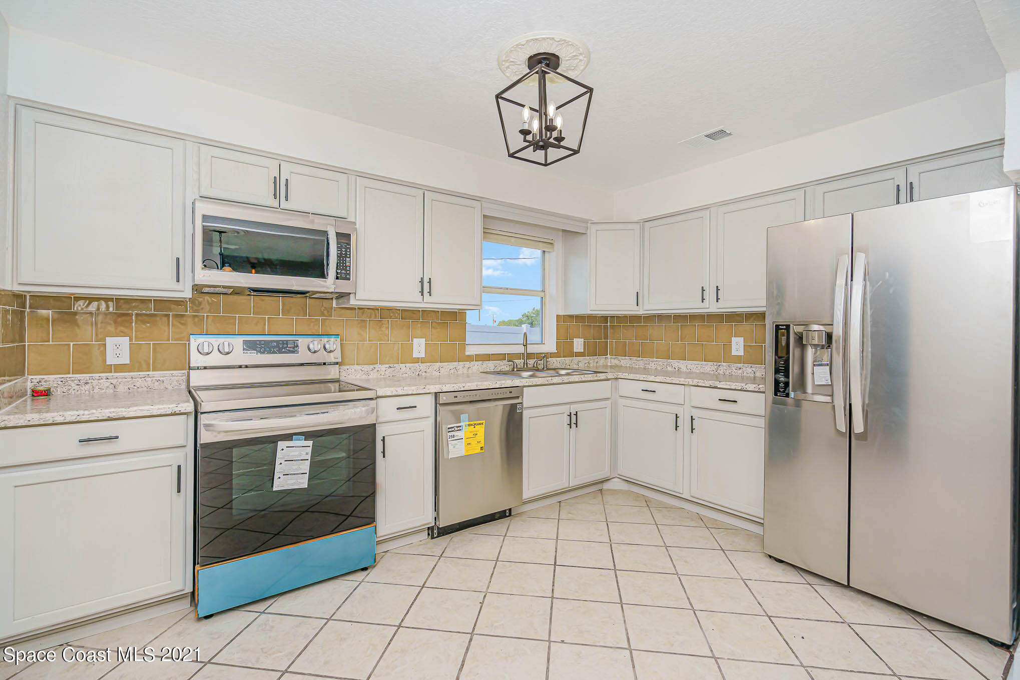 1120 North Carpenter Road Titusville, FL 32796 - Photo 7 of 22 a kitchen with a stove a sink and a refrigerator