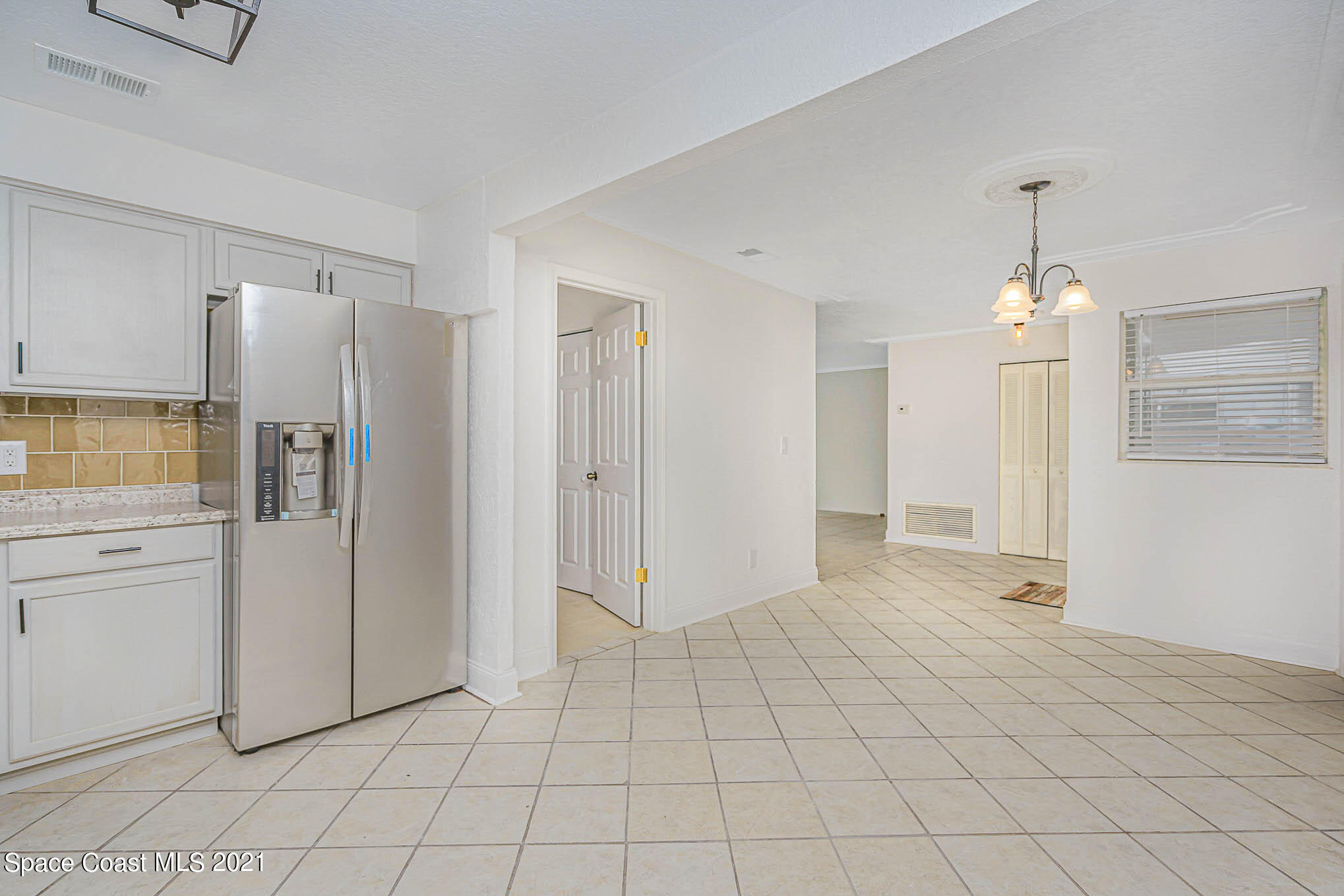 1120 North Carpenter Road Titusville, FL 32796 - Photo 8 of 22 a view of a kitchen with refrigerator and cabinets