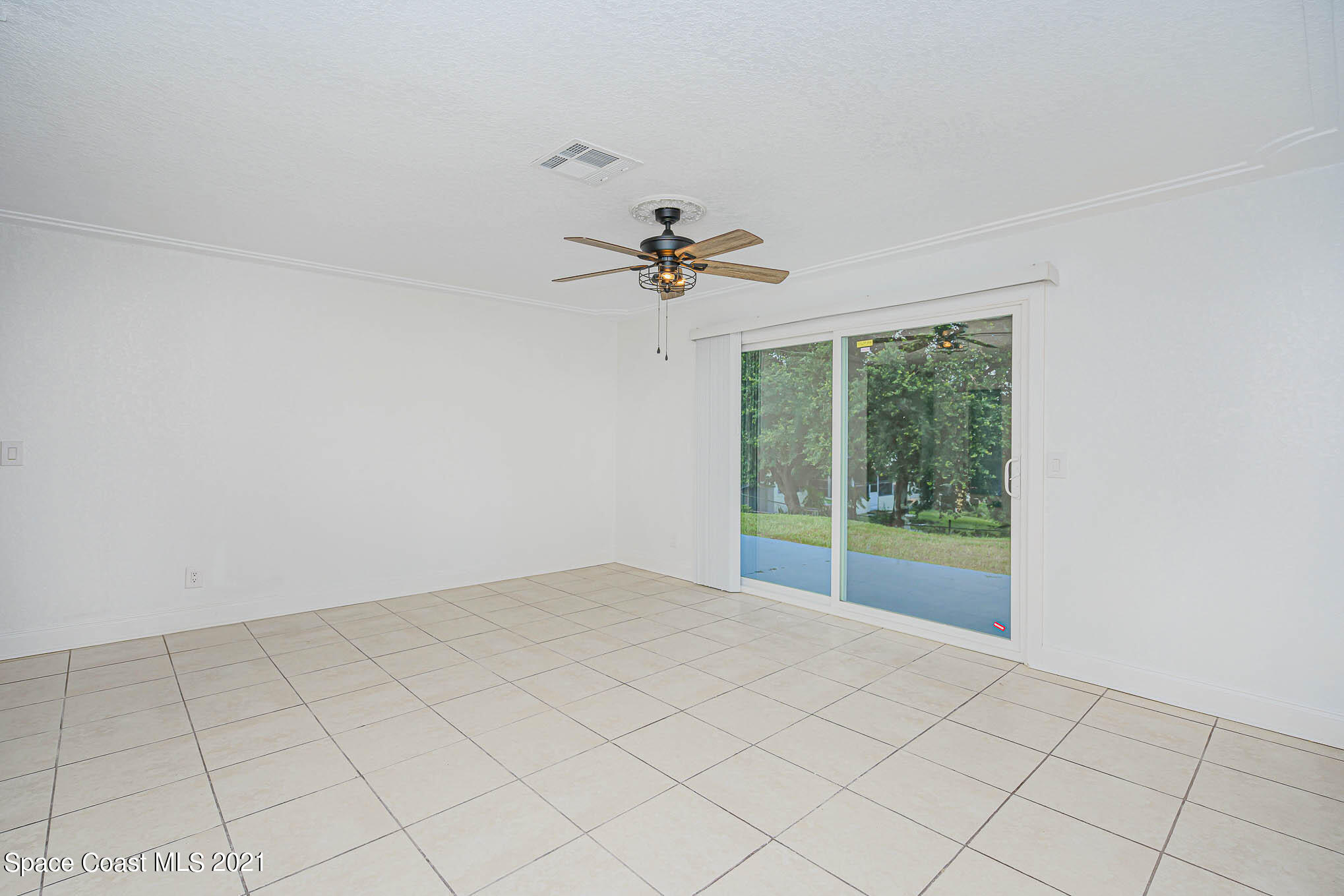 1120 North Carpenter Road Titusville, FL 32796 - Photo 10 of 22 a view of a room with a ceiling fan and a window