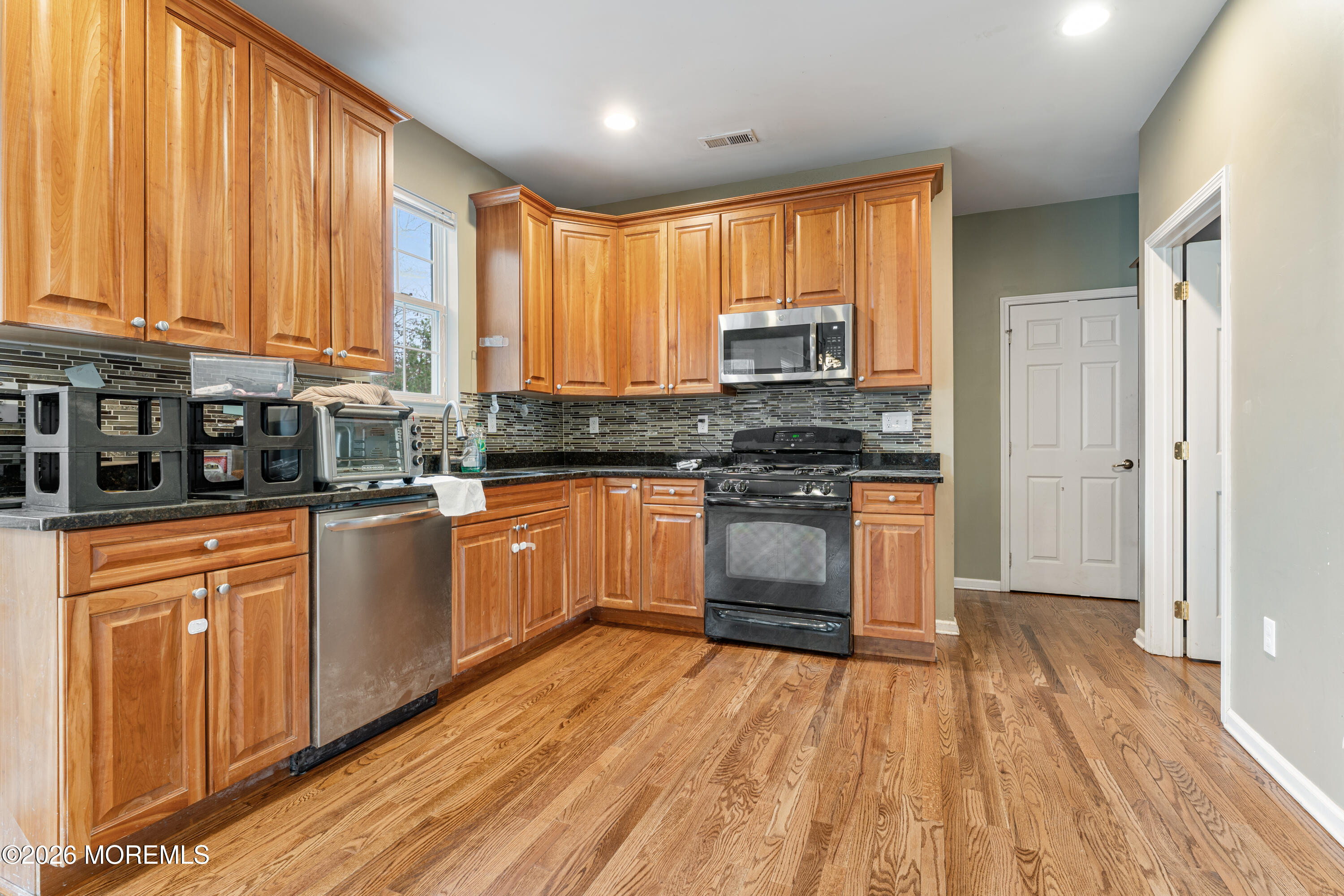 44 Imperial Place North Jackson, NJ 08527 - Photo 14 of 38 a kitchen with stainless steel appliances a stove top oven a sink dishwasher and a refrigerator with wooden floor