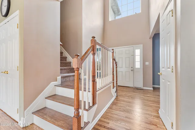 a view of a hallway with wooden floor and staircase