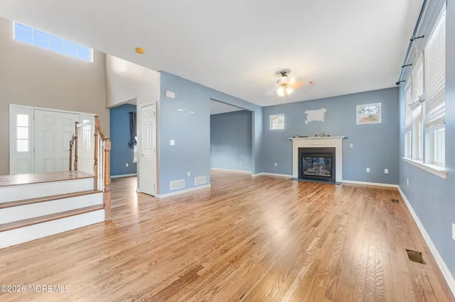 a view of empty room with wooden floor and fireplace
