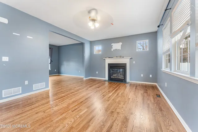 a view of empty room with wooden floor and fireplace