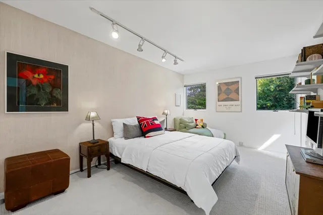 a bedroom with a bed a couch and a flat screen tv