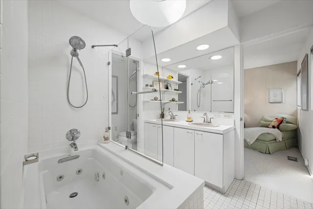 a bathroom with a tub sink and mirror