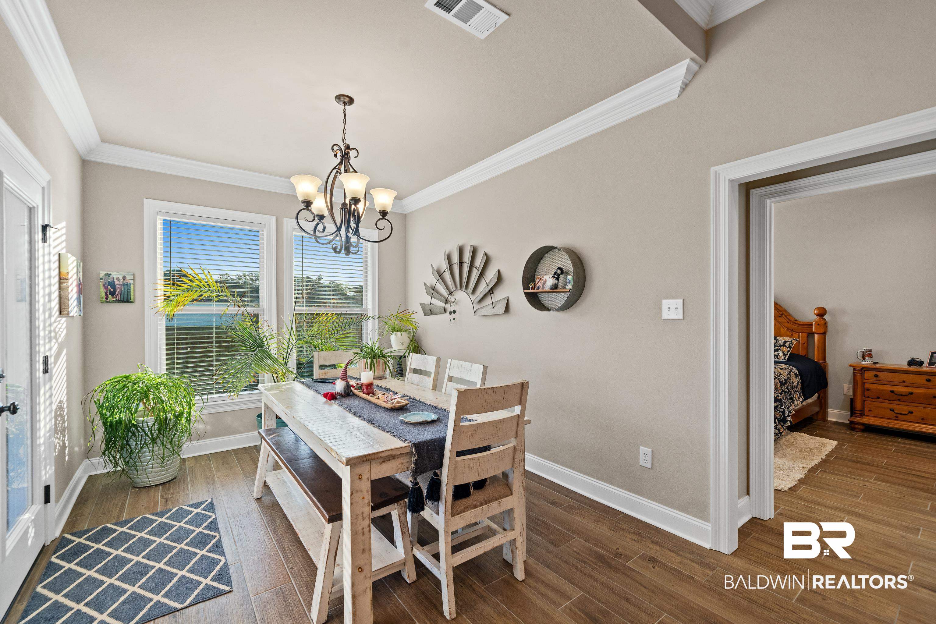 1390 Aldon Street Foley, AL 36535 - Photo 9 of 31 Dining room featuring dark wood-type flooring, crown molding, and a chandelier