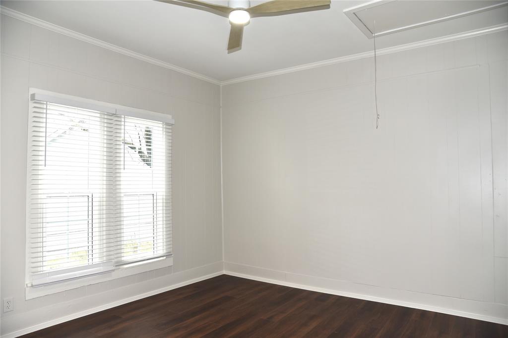 900 West Chestnut Street Denison, TX 75020 - Photo 12 of 22 an empty room with wooden floor and windows