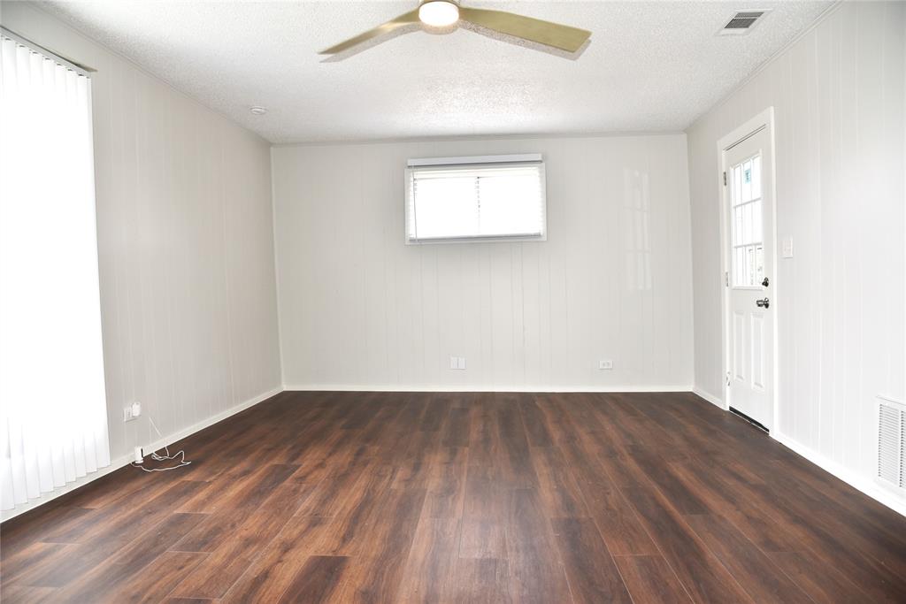 900 West Chestnut Street Denison, TX 75020 - Photo 16 of 22 an empty room with wooden floor and windows