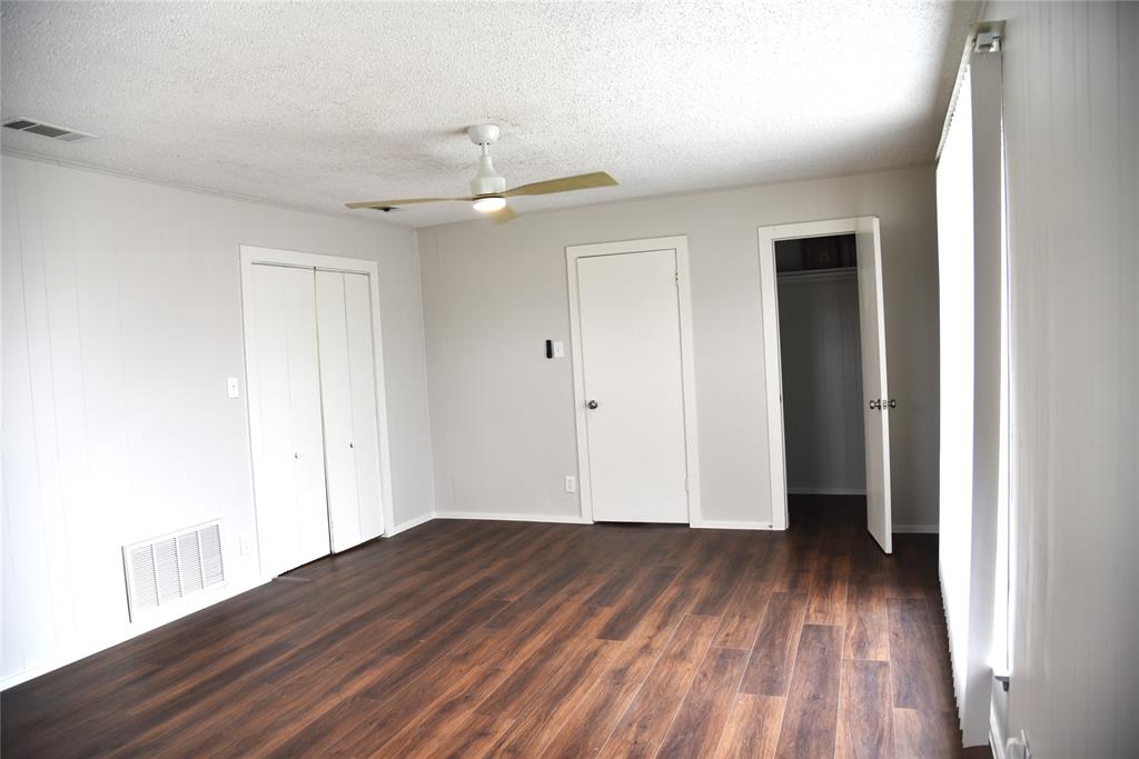 900 West Chestnut Street Denison, TX 75020 - Photo 17 of 22 an empty room with wooden floor and a ceiling fan