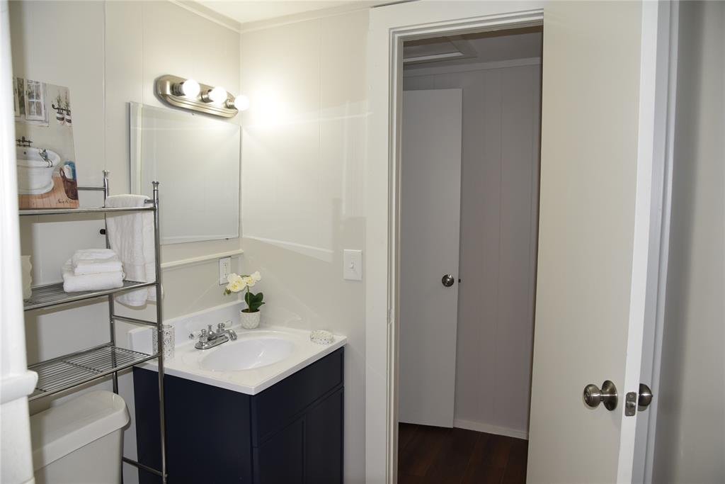 900 West Chestnut Street Denison, TX 75020 - Photo 22 of 22 a bathroom with a sink a light fixture and a mirror