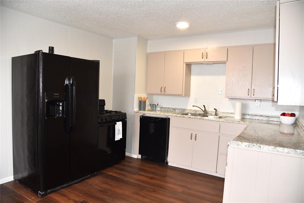 900 West Chestnut Street Denison, TX 75020 - Photo 4 of 22 a kitchen with a refrigerator and cabinets