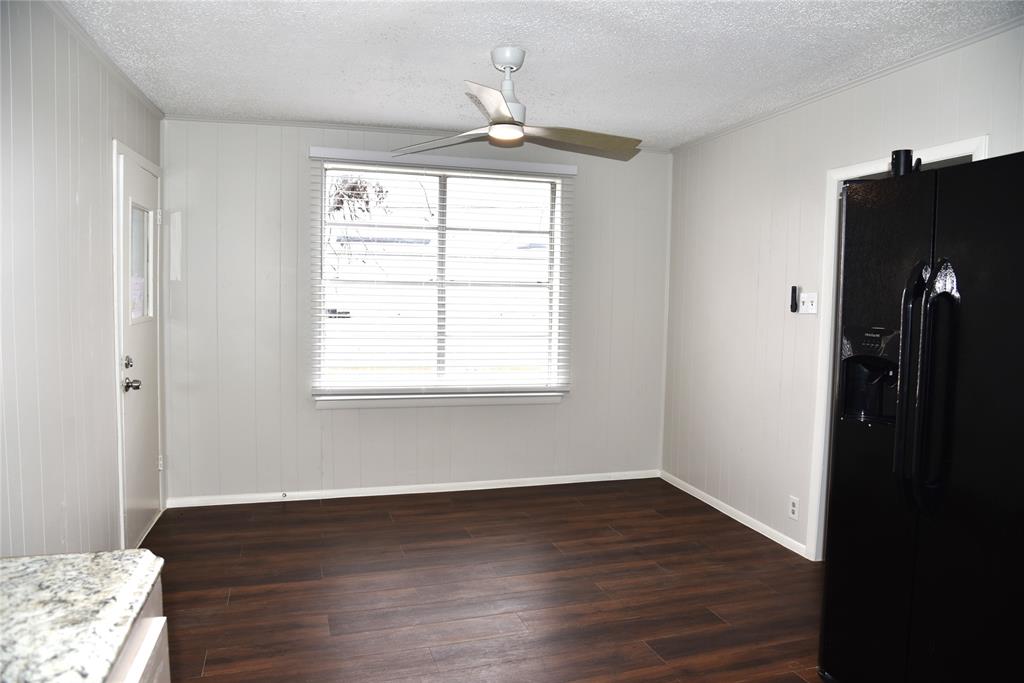 900 West Chestnut Street Denison, TX 75020 - Photo 6 of 22 a view of an empty room with wooden floor and a window