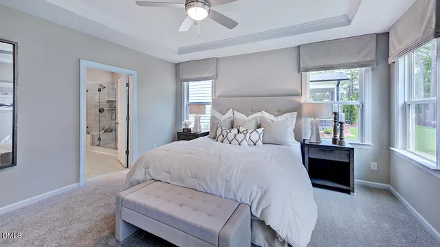 a spacious en suite bathroom with a double vanity sink a large mirror and shower