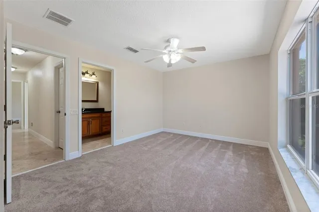 a bathroom with a granite countertop sink mirror vanity and toilet