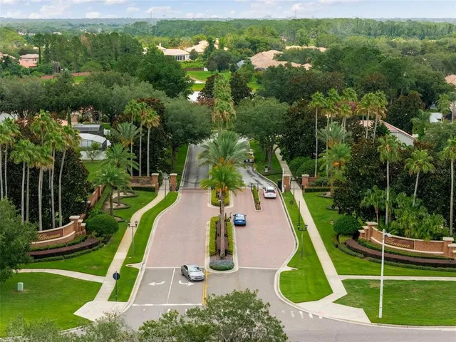 an aerial view of a residential houses with outdoor space and trees all around