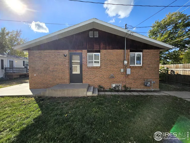 a view of a house with a small yard and wooden floor and fence