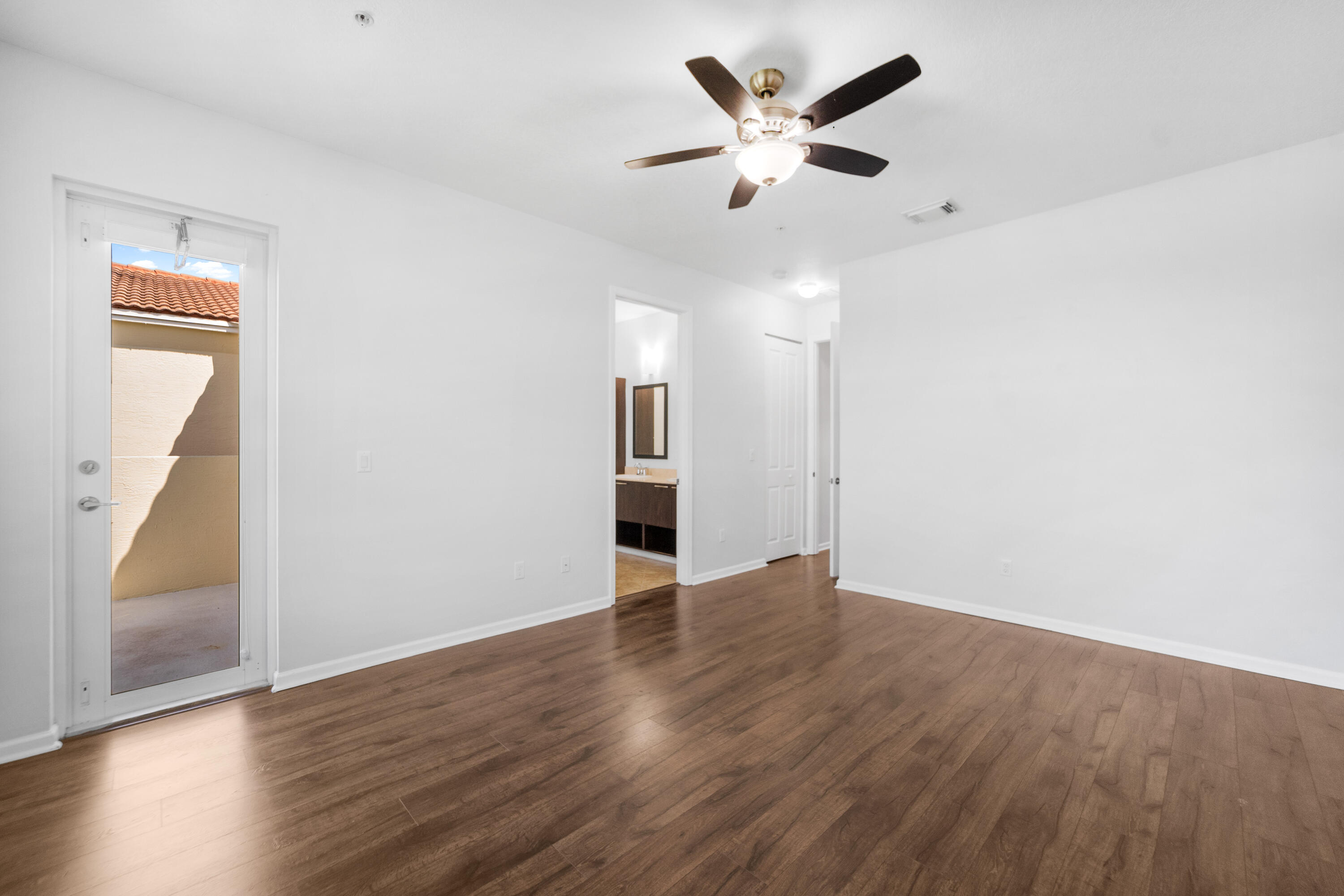 1430 Northwest 48th Lane Boca Raton, FL 33431 - Photo 27 of 54 an empty room with wooden floor and a ceiling fan