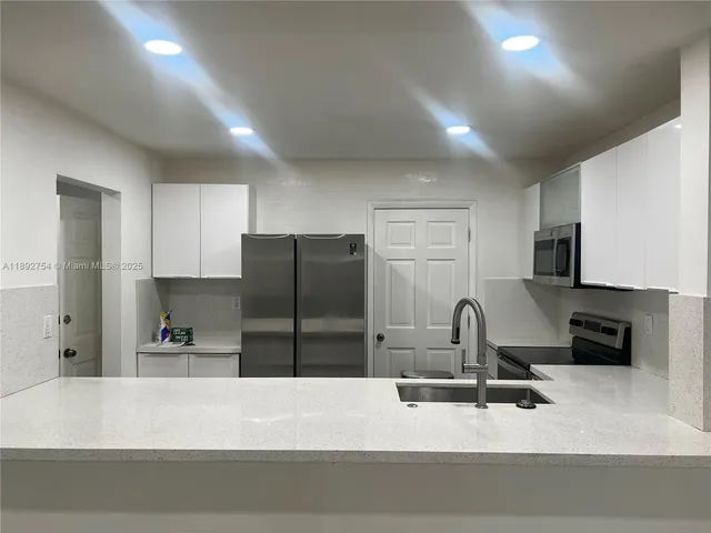 a kitchen with a refrigerator and a sink