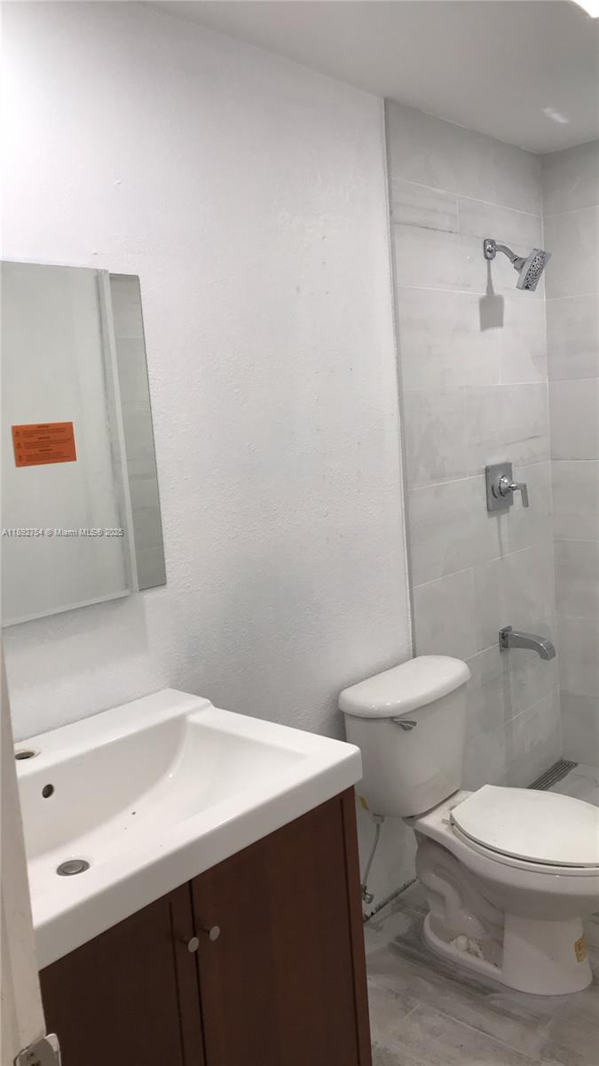 9621 Southwest 77th Avenue, Unit 108B Miami, FL 33156 - Photo 13 of 16 a bathroom with a sink a toilet and a mirror