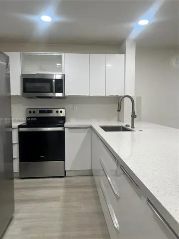 a kitchen with stainless steel appliances a stove sink and cabinets