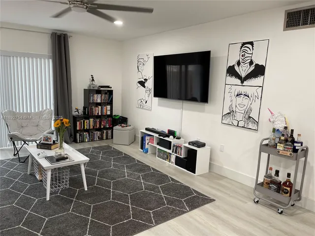 a living room with furniture a flat screen tv and rug