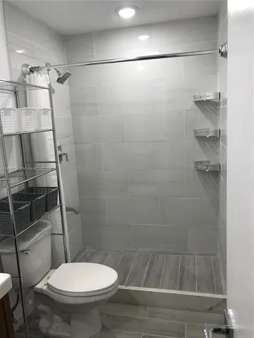 a bathroom with a toilet and a shower