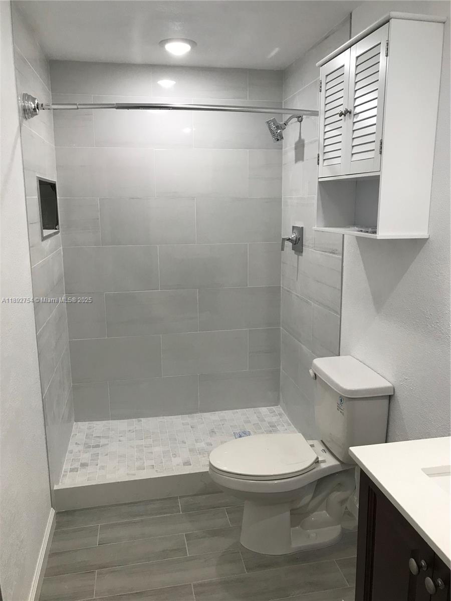 9621 Southwest 77th Avenue, Unit 108B Miami, FL 33156 - Photo 10 of 16 a bathroom with a toilet a sink and a shower