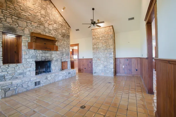 a view of empty room with wooden floor and fireplace
