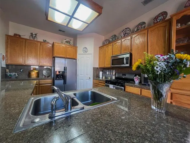 a kitchen with sink refrigerator and microwave