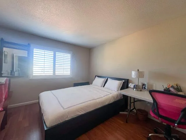 a bedroom with a bed a table and chair