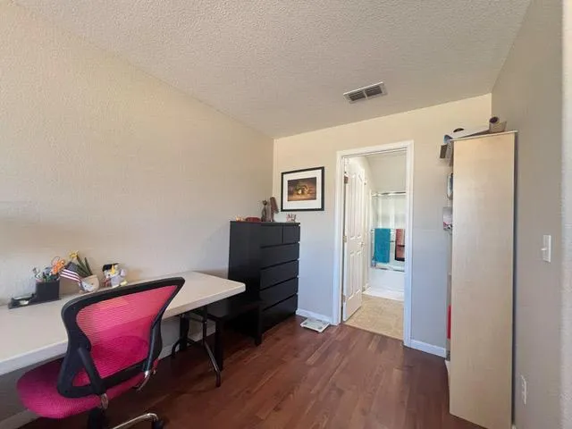 a view of a workspace with furniture and wooden floor