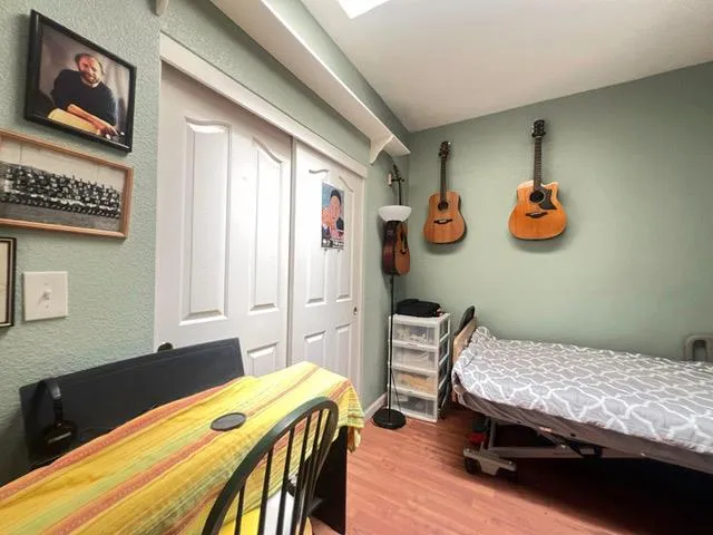 a bedroom with a bed and wooden floor