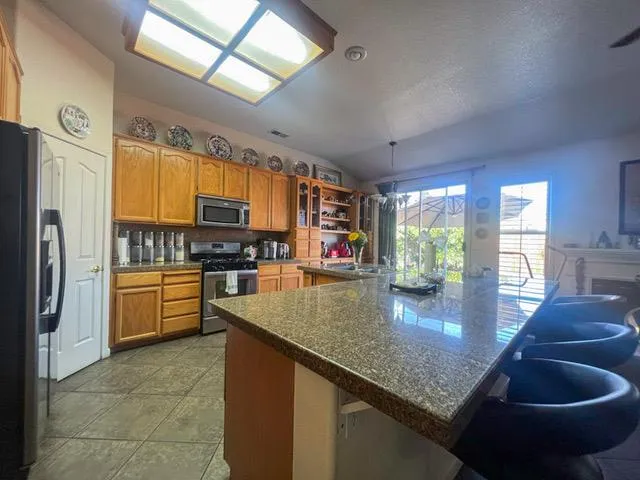 a kitchen with stainless steel appliances granite countertop a sink a stove and a refrigerator